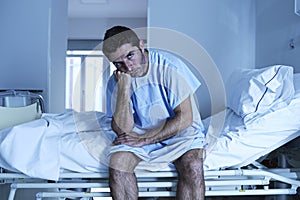 Desperate man sitting at hospital bed alone sad and devastated s