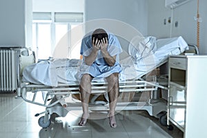 Desperate man sitting at hospital bed alone sad and devastated s