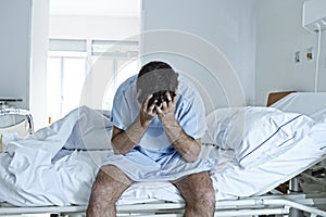 Desperate man sitting at hospital bed alone sad and devastated sick in clinic