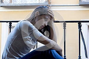 Desperate sad Latin woman at home balcony looking devastated and depressed suffering depression