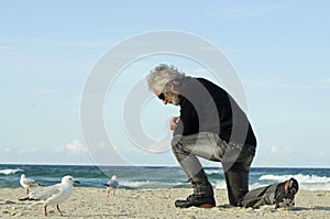 Desesperado triste solitario hombre ora sobre el Océano Playa 