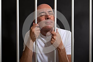 Desperate and sad man behind bars