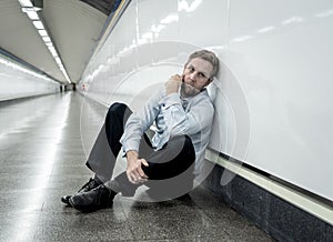 Desperate sad young businessman suffering emotional pain grief and deep depression sitting alone in tunnel subway in Stress life
