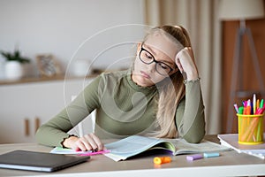 Desperate schooler looking at book, doing homework at home