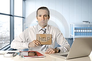 Desperate senior businessman in crisis working on computer laptop at office desk in stress under pressure