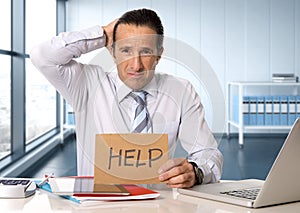 Desperate senior businessman in crisis working on computer laptop at office desk in stress under pressure