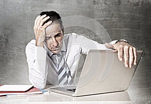 Desperate senior businessman in crisis working on computer at office