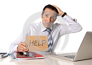 Desperate senior businessman in crisis working on computer at office in stress