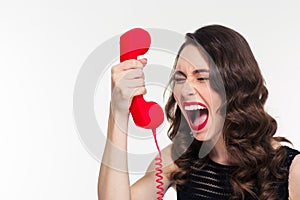 Desperate stressed woman with retro hairstyle screaming in telephone receiver