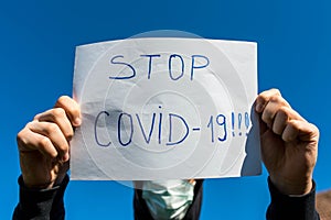 Desperate teenage boy wearing surgical mask holding a message in isolation during the new Coronavirus