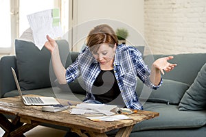 Desperate woman banking and accounting home monthly and credit card expenses with computer laptop doing paperwork