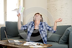 Desperate woman banking and accounting home monthly and credit card expenses with computer laptop doing paperwork