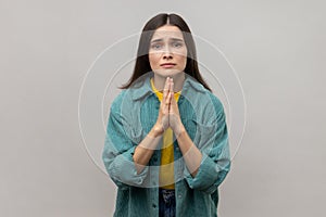 Desperate woman keeping arms in prayer gesture and asking forgiveness, feeling sorry for mistake.