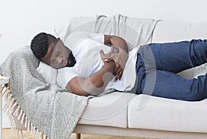 Desperate young african man hugging his belly