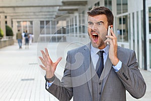 Desperate young brunette businessman get bad news heavy problems, faces challenges snort while talking on the mobile phone photo