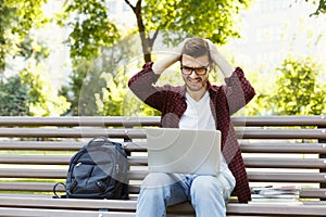 Desperate young man using laptop outdoors