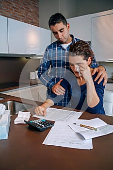 Desperate young woman with debts reviewing the bills