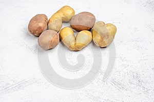 Despicable potatoes of different shapes on a gray background, copy space
