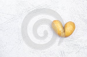 Despicable potatoes in the shape of a heart on a gray background, copy space place