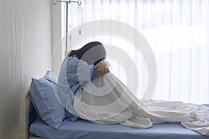 Despondent Asian woman patient. Following the doctor`s declaration that the cancer was nearing the end of its course