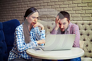 Despondent couple looking at laptop photo