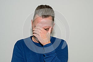 Despondent man holding his head in his hand photo