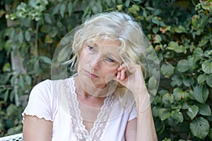Despondent middle-aged woman sitting thinking photo