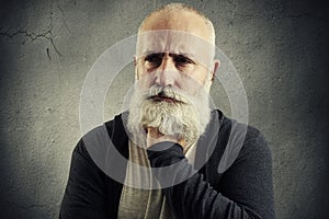 Despondent senior man over grey backround photo