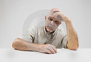 Despondent senior man sitting thinking photo