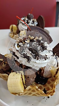 Dessert banana split: chocolate ice cream, with banana, waffle powder and nuts