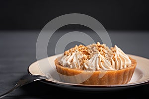 Dessert basket with caramel decorated with gold balls on a black wooden table near a fork with three prongs