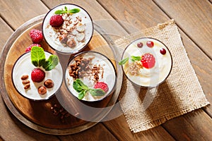 Dessert with berries, jelly, cream, nuts and mint leaf on a cutting wooden board