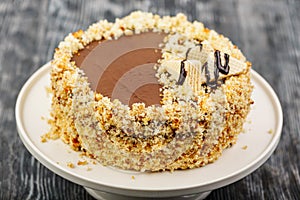 Dessert biscuit cake with impregnation and vanilla cream, chocolate glaze