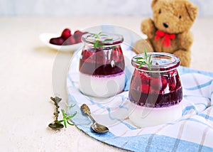 Dessert, creamy panna cotta with cherry sauce in in vintage glass jars on a light concrete background. Desserts without baking.