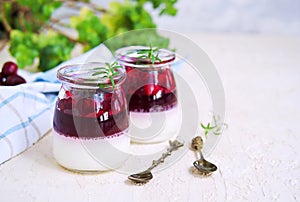 Dessert, creamy panna cotta with cherry sauce in in vintage glass jars on a light concrete background. Desserts without baking.