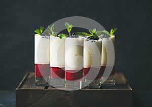 Dessert in glass with blackberries and mint over dark background
