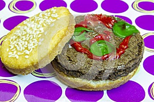 Dessert impostor hamburger on sesame seed bun with pickles and k