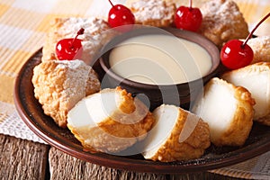 Dessert Leche frita with condensed milk and cherries closeup. ho