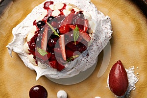 Dessert Pavloca cake with fruits and berry ice cream