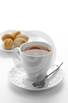 Dessert plate and cup of tea on white background