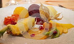 Dessert plate with various fruit slices and ice cream scoops