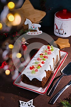 Dessert, Polish poppy seed cake with apples and candied fruits, covered with sugar icing, in Christmas style on a brown concrete