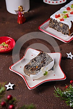 Dessert, Polish poppy seed cake with apples and candied fruits, covered with sugar icing, in Christmas style on a brown concrete