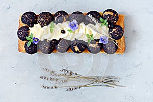 Dessert Saint Onore. Berry pie. Puff pastry tart with profiteroles, butter cream, black currant jam with fresh mint, lavender photo