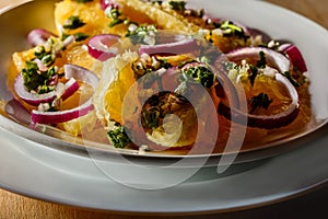 The dessert salad of oranges with red onion and olive sauce