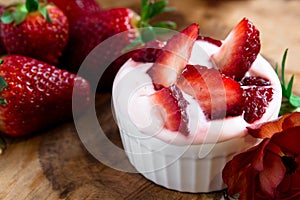 Dessert of soy yogurt and oatmeal, strawberry juice and fresh strawberries on a wooden tray,