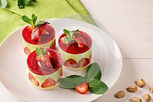 Dessert - sweet cake with strawberry on a plate with fresh mint and pistachios