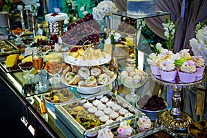 Dessert table for a party. Candy bar. Rich thematic wedding candy bar high variety of sweets