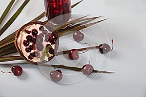 Dessert of whipped cream and fresh cherries and currants, cherry juice with ice, palm leaves on a white table. Top view. Copy