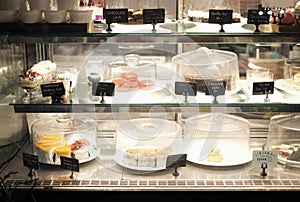 Desserts on sell with names and prices in bakery shop